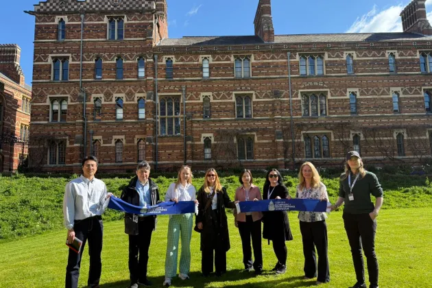 En grupp människor framför ett stort pampigt hus